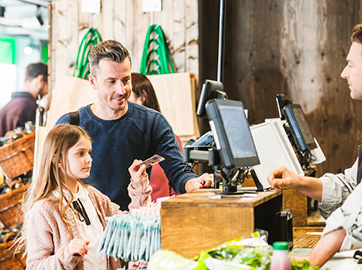 Girl and father pay with card in store