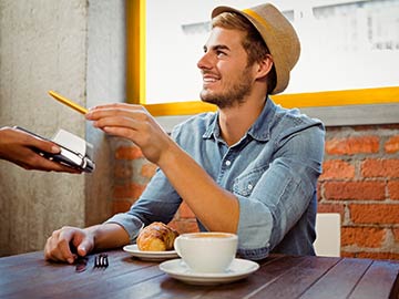 Glad mand med hat blipper kortet